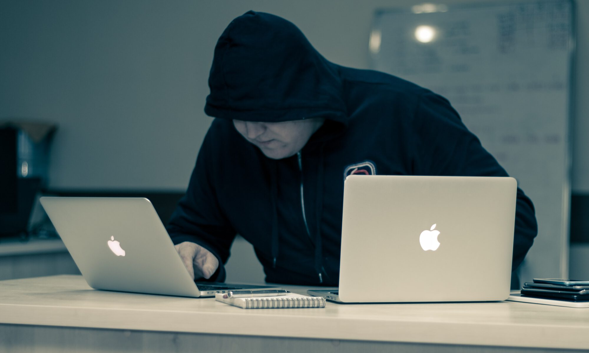 man in black hoodie using macbook